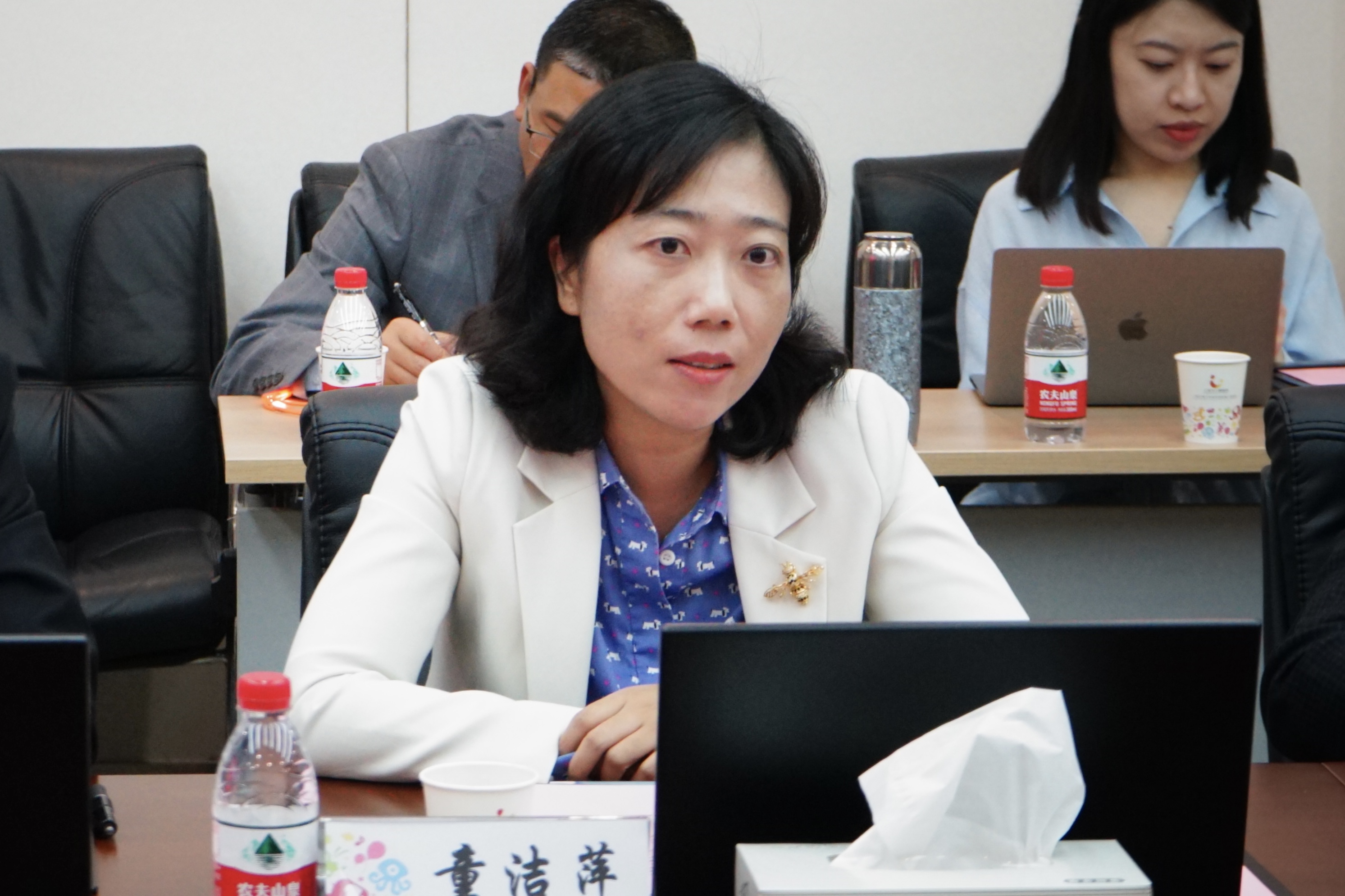 桌子上放着笔记本电脑的人中度可信度描述已自动生成